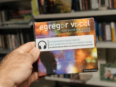 Münih, Almanya - 9 Ağustos 2025: Egregor Vocal 'ın ön kapağı dünyayı çevreleyen renkli bir müzik CD' si, ses odasında el ele tutulan ikili kayıt notalarını gösteriyor.