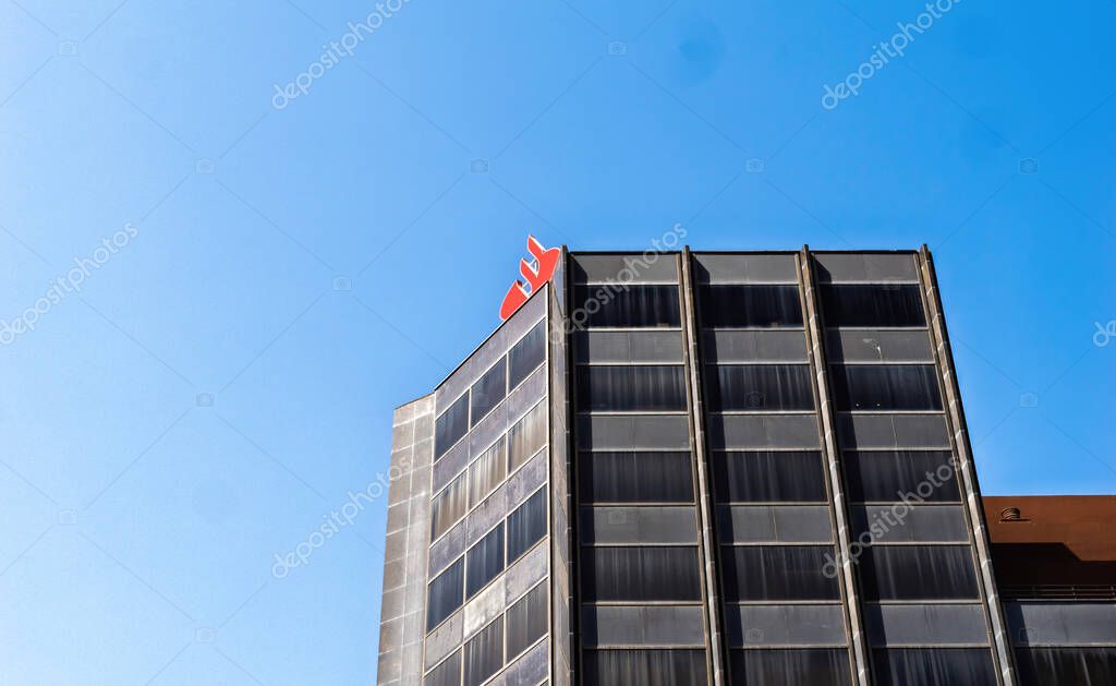 Palma, Spain - Jul 15, 2025: View of Santander bank headquarters building in Palma Mallorca Spain with red logo and clear blue sky above.