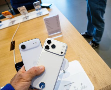 Paris, Fransa - 19 Eylül 2025: Apple iPhone Air ve iPhone 17 Pro 'yu Apple Store' da tutan kişi, iki akıllı telefon modeli arasındaki farklı kamera tasarımlarını karşılaştırdı.