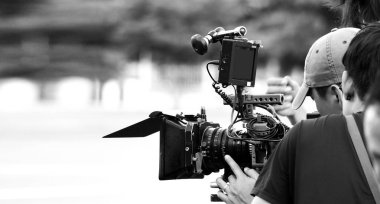 Yüksek çözünürlüklü dijital video kameranın görüş açısı hangi kayıt veya tv ticari üretim pan tilt üst karakter kümesiyle açık konumu ve film ekibi takım'deki profesyonel baş tripod üzerinde çekim geri.