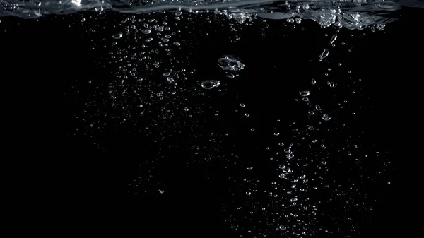 近距离图像的苏打水溅在水中的许多小气泡 使其感觉像清新和黑色的背景 — 图库照片