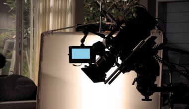 Kameraman ve film ekibi tarafından sette çalışan ya da çekim yapan televizyon stüdyosundaki video kameranın siluet görüntüleri. Profesyonel vinç ve tripodları, eğilmesi ya da kayması kolay olsun diye destekliyorlar.