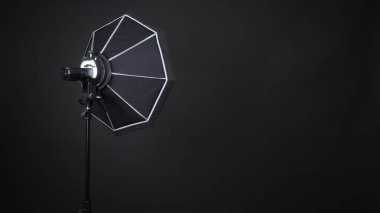 Professional photo studio soft box and flash on the tripod for stillphoto or video production which ready for shape the light for softer, harder or sharper by crew team before shooting on black background. clipart