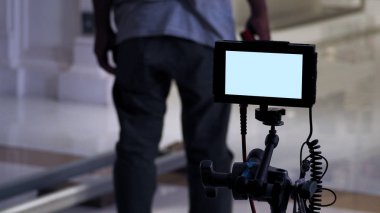 Bir sonraki çekim için hazırlanan ve yönetmen ve ajans ya da müşterilerin onayını bekleyen televizyon reklam çekimi ve film ekibi kamera arkası veya video yapım monitörü.
