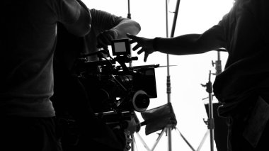 Yüksek çözünürlüklü kamera, monitörler ve ekipmanlı LED ışığı gibi profesyonel ekipmanlarla büyük stüdyo prodüksiyonunda çevrimiçi ticari veya web film kaydı yapan kamera arkasında