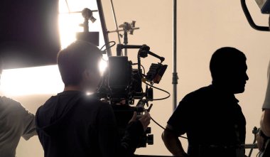Yüksek çözünürlüklü kamera, monitörler ve ekipmanlı LED ışığı gibi profesyonel ekipmanlarla büyük stüdyo prodüksiyonunda çevrimiçi ticari veya web film kaydı yapan kamera arkasında