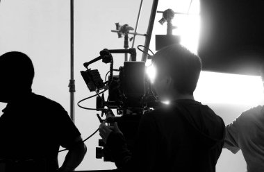 Yüksek çözünürlüklü kamera, monitörler ve ekipmanlı LED ışığı gibi profesyonel ekipmanlarla büyük stüdyo prodüksiyonunda çevrimiçi ticari veya web film kaydı yapan kamera arkasında