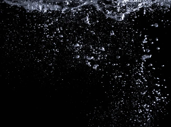 Imágenes borrosas de burbujas de soda salpicando en el fondo negro — Foto de Stock