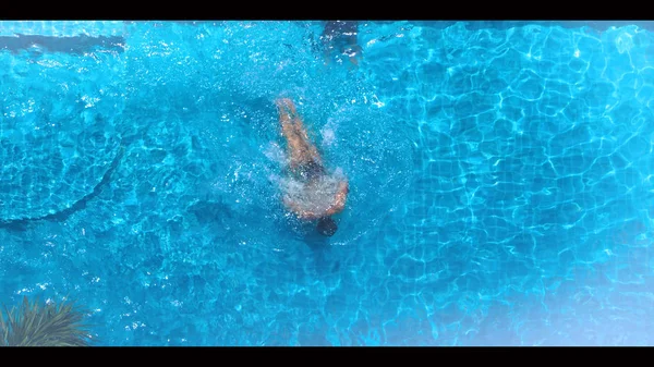 Ángulo de vista superior de la piscina que el agua clara de color azul y la luz del sol reflejan en la textura de la superficie y las imágenes conceptuales para la relajación o las vacaciones o el deporte en el verano tropical y para un estilo de vida saludable — Foto de Stock