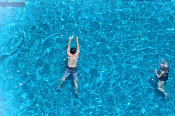 Swimming pool top view angle which blue color clear water and sun light reflect on surface texture and concept images for relaxation or vacation or sport in the tropical summer and for healthy lifestyle