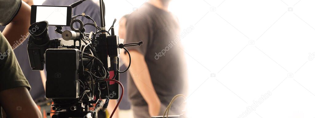 Behind the scenes of video recording or filming online movie by 8K high definition digital camera and professional monitor. And flare lighting set up with film crew team in the studio production.