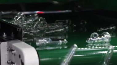PET preformları. Şeffaf PET plastik preformların yapımı modern fabrikada otomatik taşıma bandı boyunca ilerler. İçecek şişeleri ambalaj otomasyon geri dönüşümü endüstriyel üretim hattı kavramı.