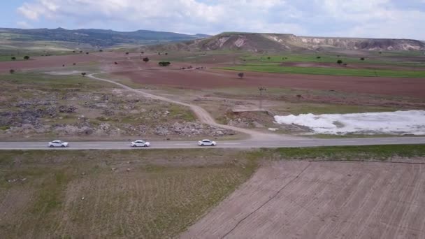 Vista aerea auto elettrica guida su strada di campagna, auto di lusso guida attraverso la nebbia al crepuscolo con fari — Video Stock