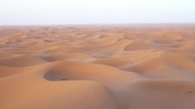 Güneş doğarken Sahra Çölü 'ndeki kum tepelerinin havadan görünüşü, Afrika, 4k