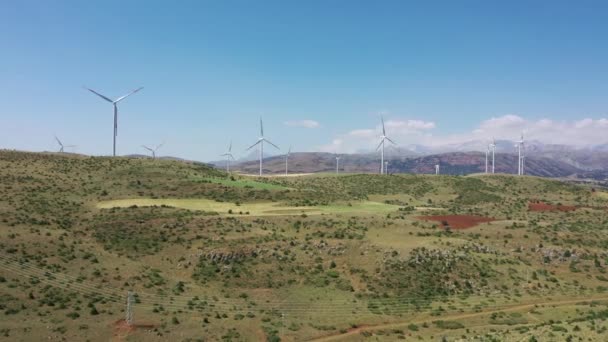 Turbinas de viento con un tractor de granja en el campo. Campos polvorientos de labranza de tractores cerca de la base de aerogeneradores en Thrace, Turquía — Vídeo de stock