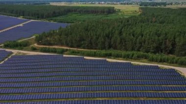 Güneş Panelleri Çiftliği güneş ışığı ile güneş pili 4k Havadan görünümü. Drone uçuş güneş panelleri üzerinde uçmak,2019