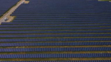 Güneş Panelleri Çiftliği güneş ışığı ile güneş pili 4k Havadan görünümü. Drone uçuş güneş panelleri üzerinde uçmak,2019