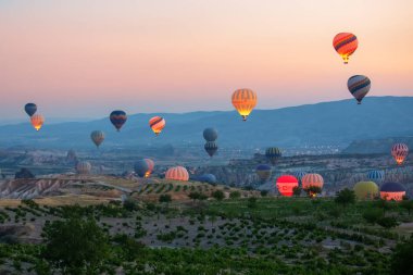 İlginç bir kayalık arazi ve havada bir sürü renkli toplar var. Hindi. Kapadokya.