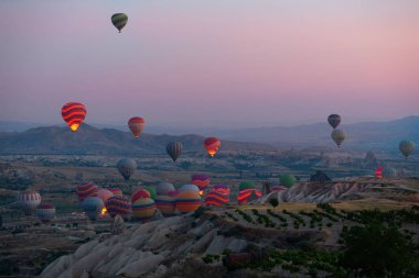 İlginç bir kayalık arazi ve havada bir sürü renkli toplar var. Hindi. Kapadokya.