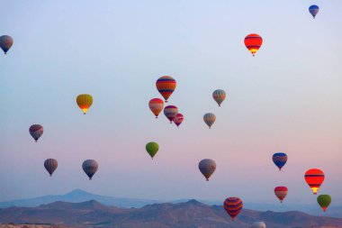 İlginç bir kayalık arazi ve havada bir sürü renkli toplar var. Hindi. Kapadokya.