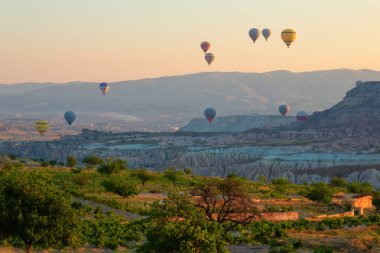 İlginç bir kayalık arazi ve havada bir sürü renkli toplar var. Hindi. Kapadokya.