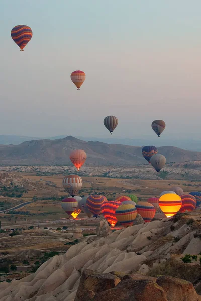 Terreno rochoso interessante e um monte de bolas multicoloridas arejadas no ar. A Turquia. Capadócia . — Fotografia de Stock