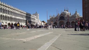 Turistler dar sokaklarda dolaşırken Venedik İtalya 'daki birçok arka kanaldan birinde tekneler yüzüyor.