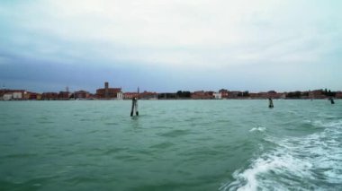 Turistler dar sokaklarda dolaşırken Venedik İtalya 'daki birçok arka kanaldan birinde tekneler yüzüyor.