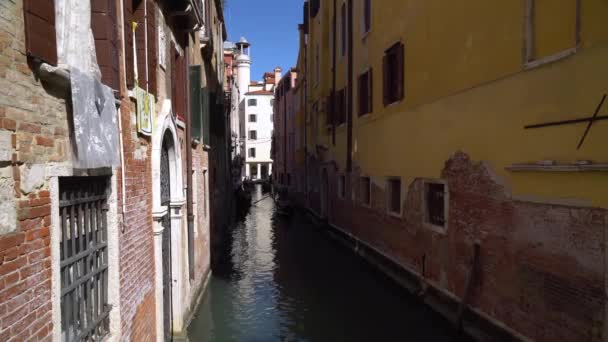 Boten drijven op een van de vele achterkanalen in Venetië Italië als toeristen zwerven door de smalle straatjes — Stockvideo