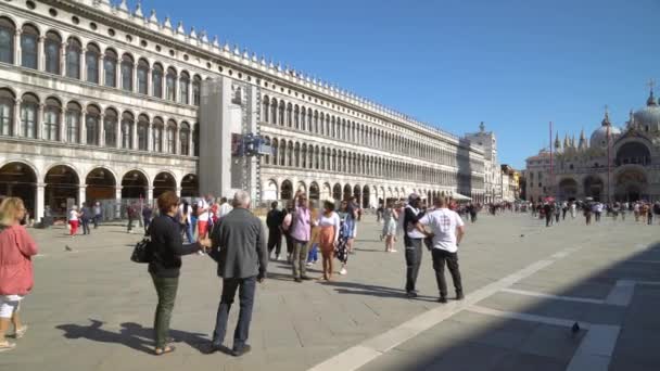 Hajók lebegnek a sok hátsó csatorna egyikén Velencében Olaszországban, miközben turisták kóborolnak a szűk utcákon. — Stock videók