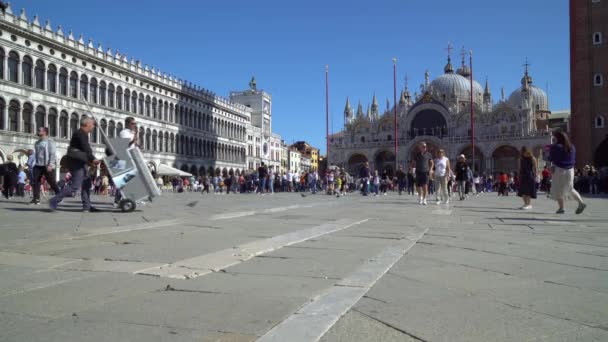 Łodzie pływają na jednym z wielu kanałów w Wenecji Włochy jak turyści wędrują wąskimi uliczkami — Wideo stockowe