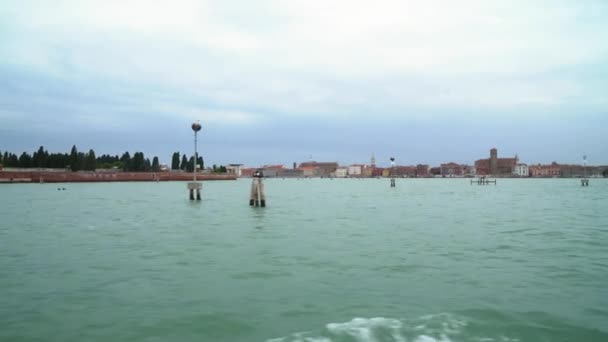 Лодки плавают по одному из многих задних каналов в Венеции, когда туристы бродят по узким улочкам — стоковое видео