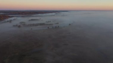 4K hava bakış açısı. Nehrin üzerinde güneşli ve sisli bir sabah