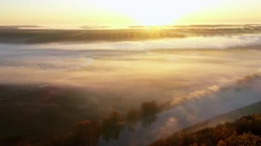 4K hava bakış açısı. Nehrin üzerinde güneşli ve sisli bir sabah