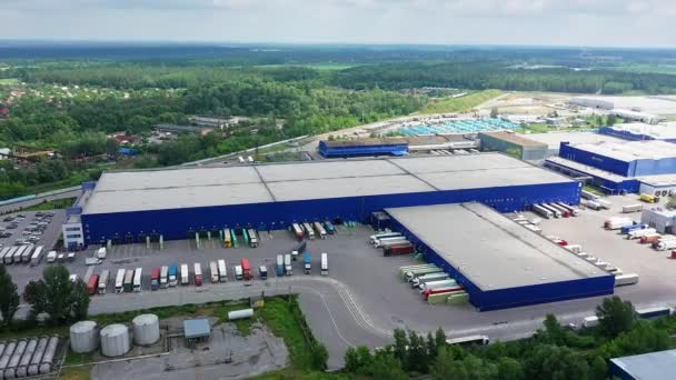 Vista de círculo aéreo do centro de logística com armazém, hub de carregamento com muitos semi-reboques carga de caminhão . — Vídeo de Stock