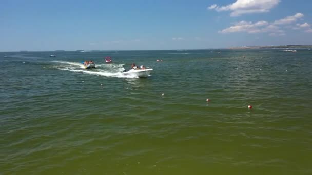 Vuelo Drone Aerial drone siguiendo Banana barco lleno de gente divirtiéndose en el mar — Vídeo de stock