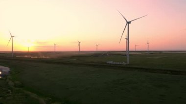 Güzel bir akşam güneşinin arka planına karşı bir rüzgar çiftliği. Yeşil ekolojik dünya için yenilenebilir enerji üretimi. Hava görünümü.