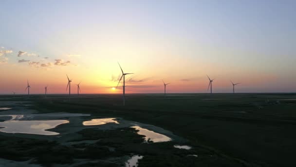 美しい夜の黄金の夕日を背景にした風力発電所。緑の生態系の世界のための再生可能エネルギー生産。空中風景. — ストック動画