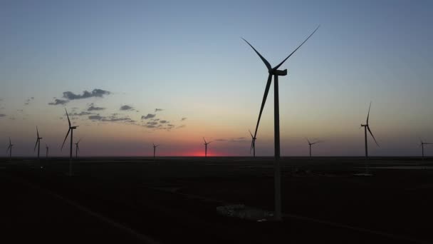 Větrná farma na pozadí krásného večerního zlatého západu slunce. Výroba obnovitelné energie pro ekologický svět. Letecký pohled. — Stock video