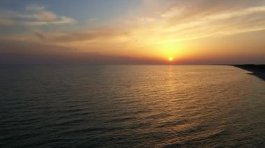 İnanılmaz sarı-pembe gün batımı denizin üzerinde.