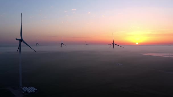 Ветряная электростанция на фоне красивого вечернего золотого заката Производство возобновляемой энергии для зеленого экологического мира. Вид с воздуха. — стоковое видео