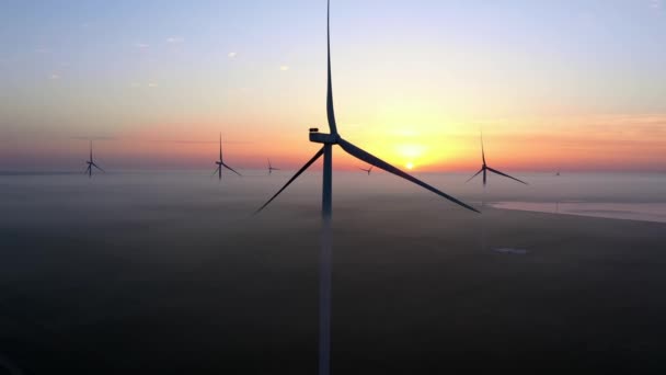 Wind farm against the backdrop of a beautiful evening golden sunset Renewable energy production for a green ecological world. Aerial view. — Stock Video