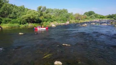 Rouge River 'da rafting yapan insanların hava görüntüsü. Whitewater rafting ekipleri su sıçratan raketlerle azgın akıntılara doğru iniyor. Beyaz suda üç rafting teknesi.