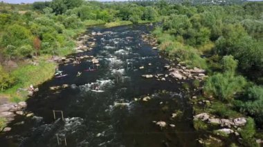 Rouge River 'da rafting yapan insanların hava görüntüsü. Whitewater rafting ekipleri su sıçratan raketlerle azgın akıntılara doğru iniyor. Beyaz suda üç rafting teknesi.