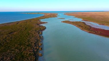 Gün batımında adanın sonbahar bozkır manzarası, sonbaharda Dzharylgach adasının havadan görüntüsü, deniz kenarındaki göllerin hava manzarası, gün batımında adanın göl manzarası.