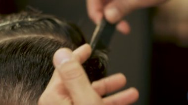 El saç kesici ıslak saç tarak ve yakın çekim için kuaförlük makas kullanarak