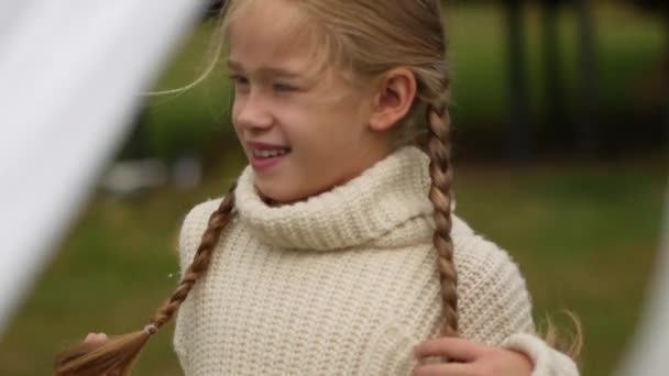 白いセーターにピグテールのある少女の肖像。子供の頃の記憶。スローモーションでヴィンテージ時間。家族の境界。家族の肖像画ファミリークロニクル — ストック動画