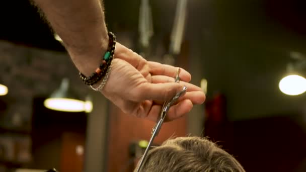 Barbeiro corta o cabelo do cliente com tesoura close-up . — Vídeo de Stock