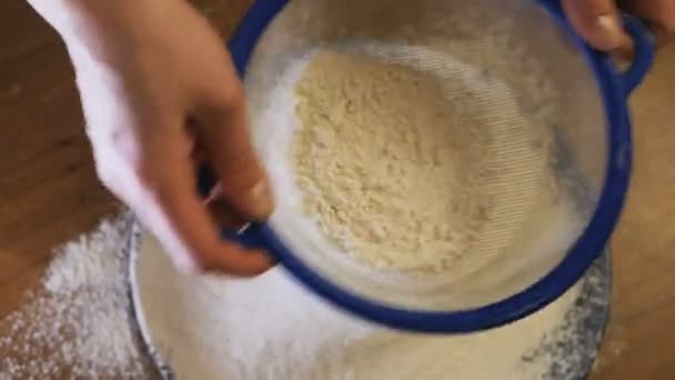 スローモーション。ふるいのほつれを通して小麦粉のクローズアップ。小麦粉をふるいにかけます。ベーキング。成分と準備段階。小麦粉は雪に似ている. — ストック動画