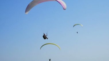 Birçok yamaç paraşütçüsi uçuyor. Siluet insanlar Yamaç paraşütü. Yamaç paraşütle uçuş deneyimi skydive yaz.